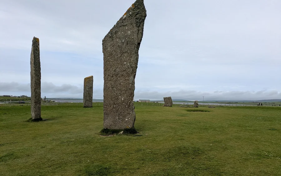 Tall thin standing stones on mown grass under a grey sky