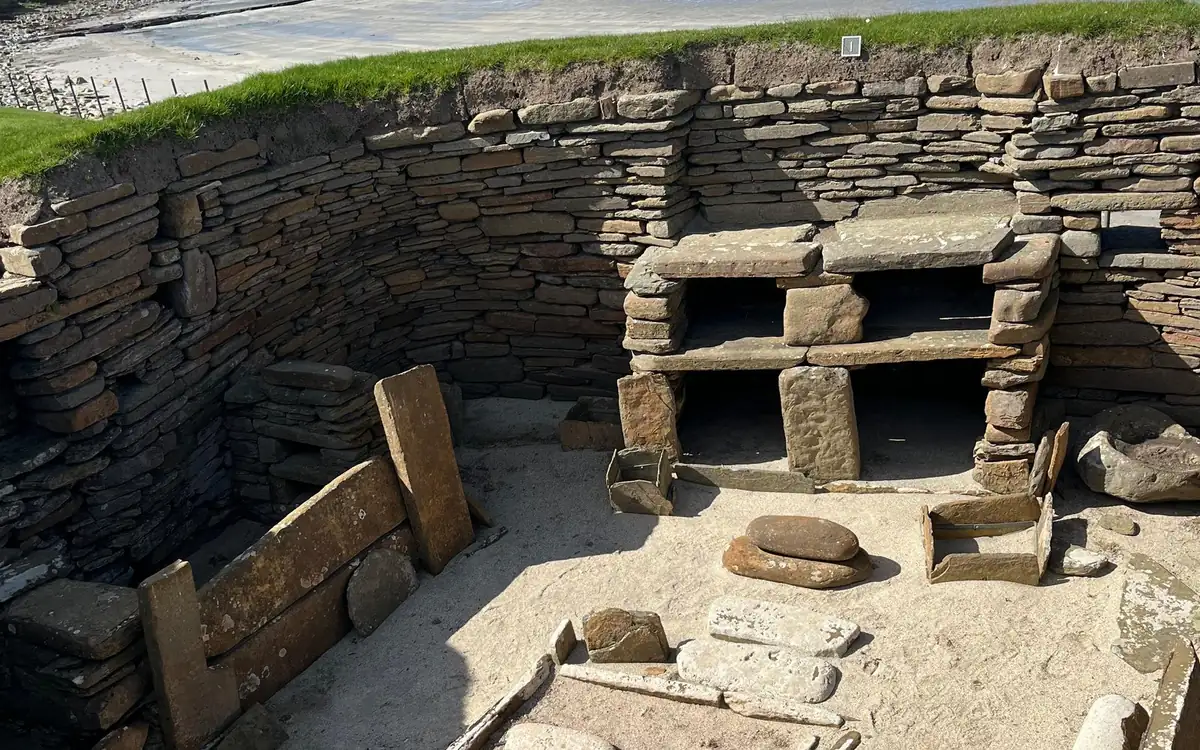 A stone dresser and hearth inside a sunken Neolithic house